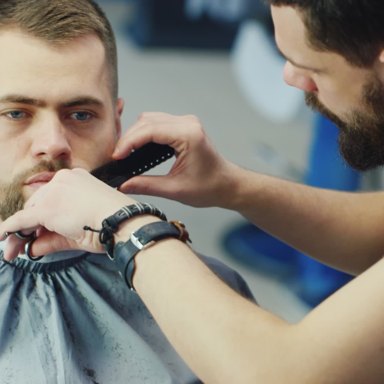 peluquero corta y da forma a la barba del cliente en la barbería