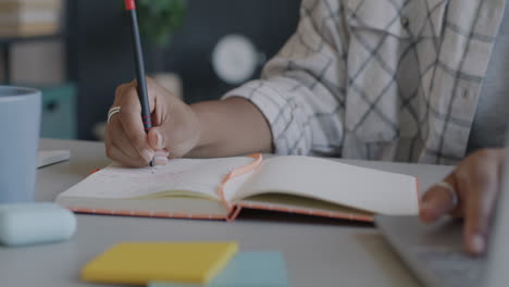 persona escribiendo en un cuaderno en un escritorio