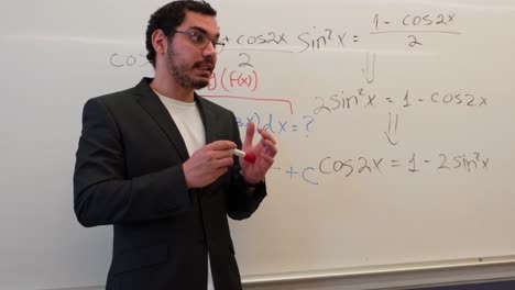 teacher demonstrating a problem on a whiteboard