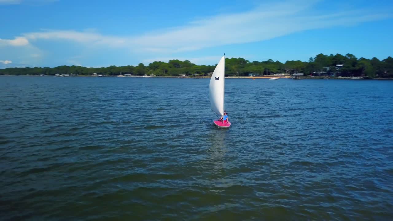 Drone orbits a small sailboat in the vast ocean