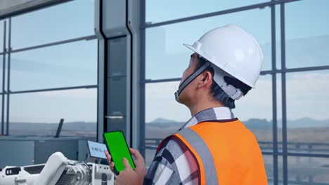 ingeniero de monitoreo de equipos industriales con teléfono inteligente