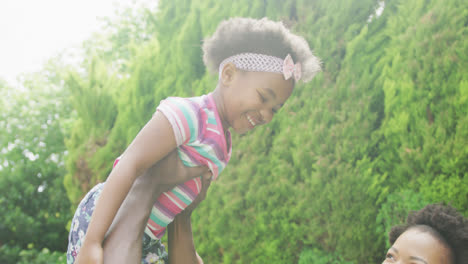 happy african american couple with their daughter playing in garden