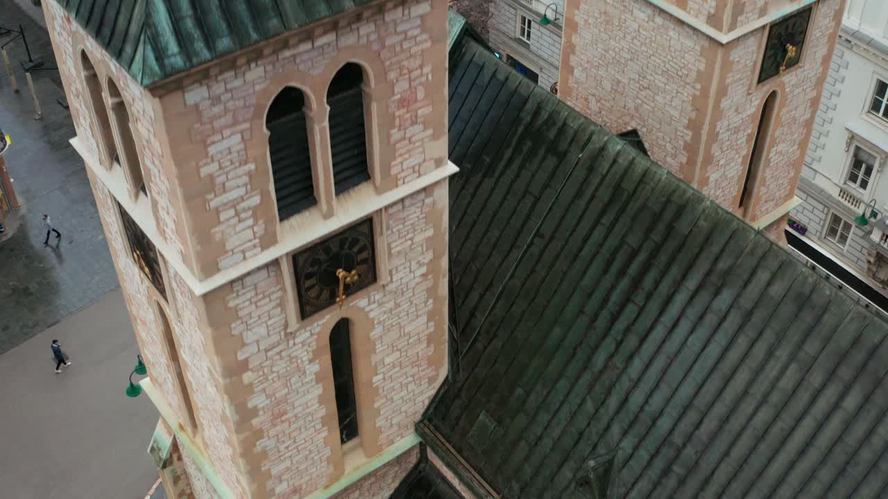 Exterior Details Of Bell Towers With Clocks And Roof Of Sacred Heart Cathedral In Sarajevo, Bosnia And Herzegovina. aerial drone descend