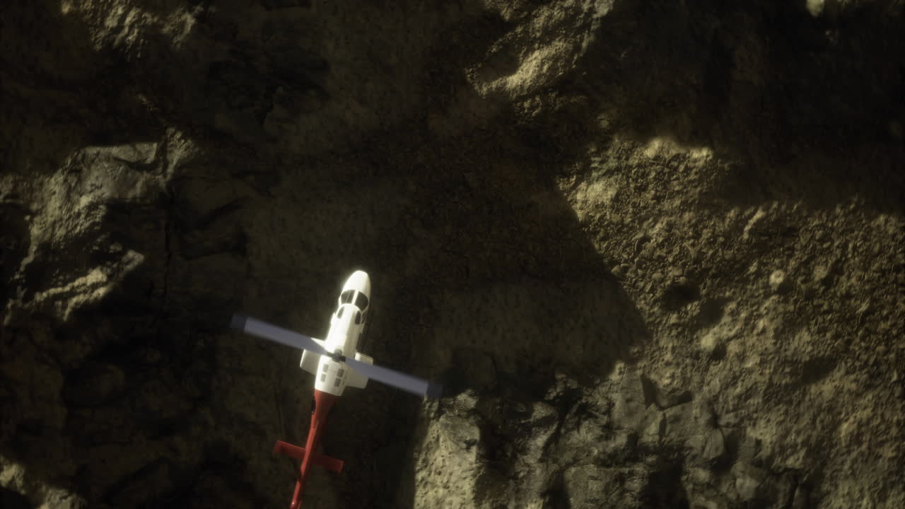 Helicopter flying over rocky cliff during midday in remote wilderness