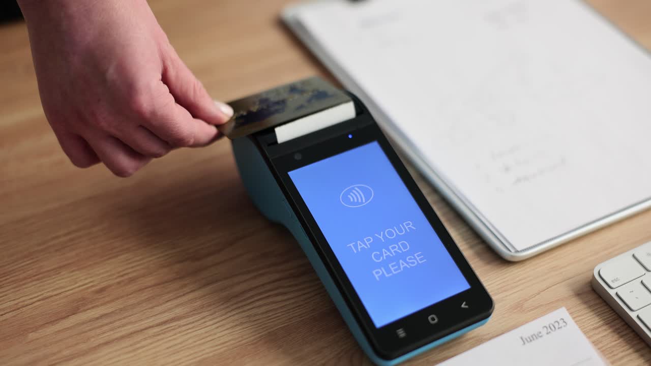 Woman hand puts credit card to wireless payment terminal