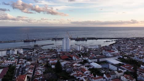 aerial view of coastal city with harbor at sunset