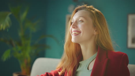 una chica hermosa sonriendo sentada en el sofá.