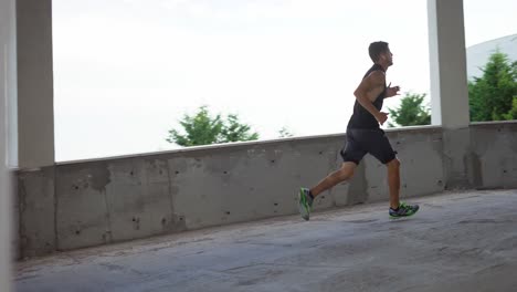 athlete runs around by levels of and empty parking garage