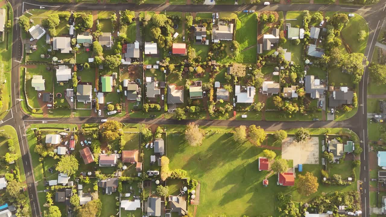 Houses and garden with junction on Oneroa Area, Haiheke Island, New Zealand. Aerial top down shot. Sunset time in quiet housing neighborhood of NZ.