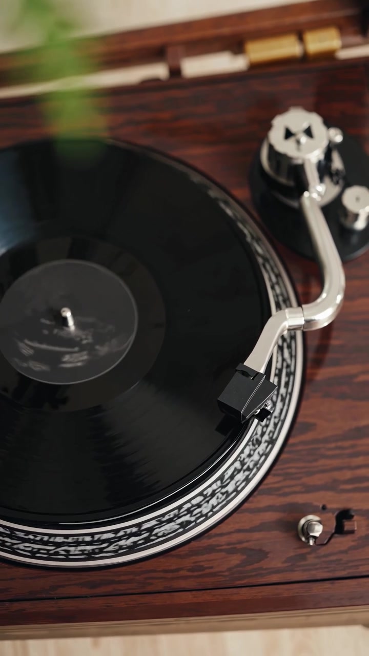 Primo piano di un braccio del giradischi che viene posizionato su un disco in vinile che gira