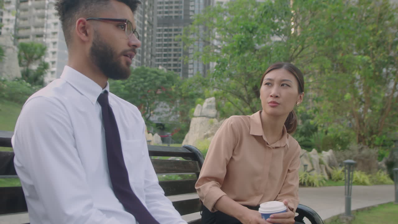 Coworkers Having Coffee and Talking in Park