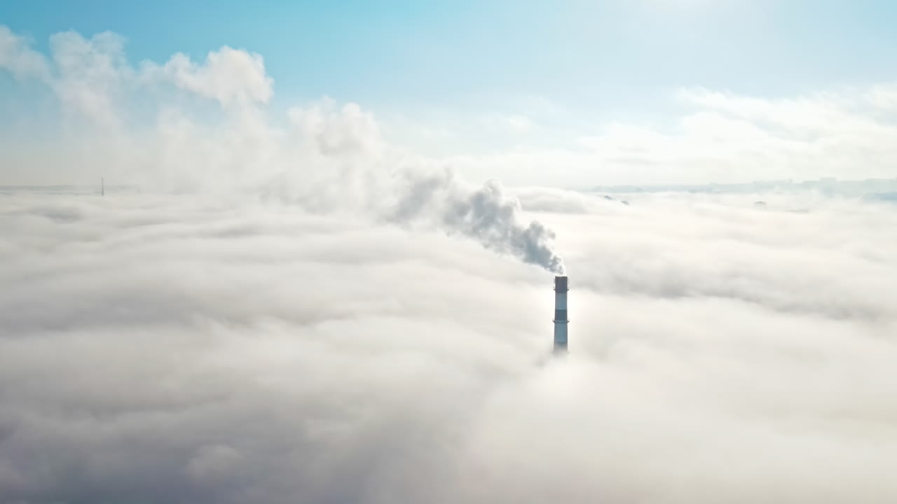 Aerial drone view of Chisinau. Tube of the thermal station with smoke coming out above the low clouds. Visible buildings. Moldova