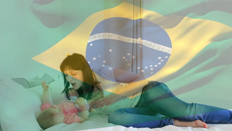 video compuesto de agitar la bandera de brasil contra una madre caucásica jugando con su hija en casa