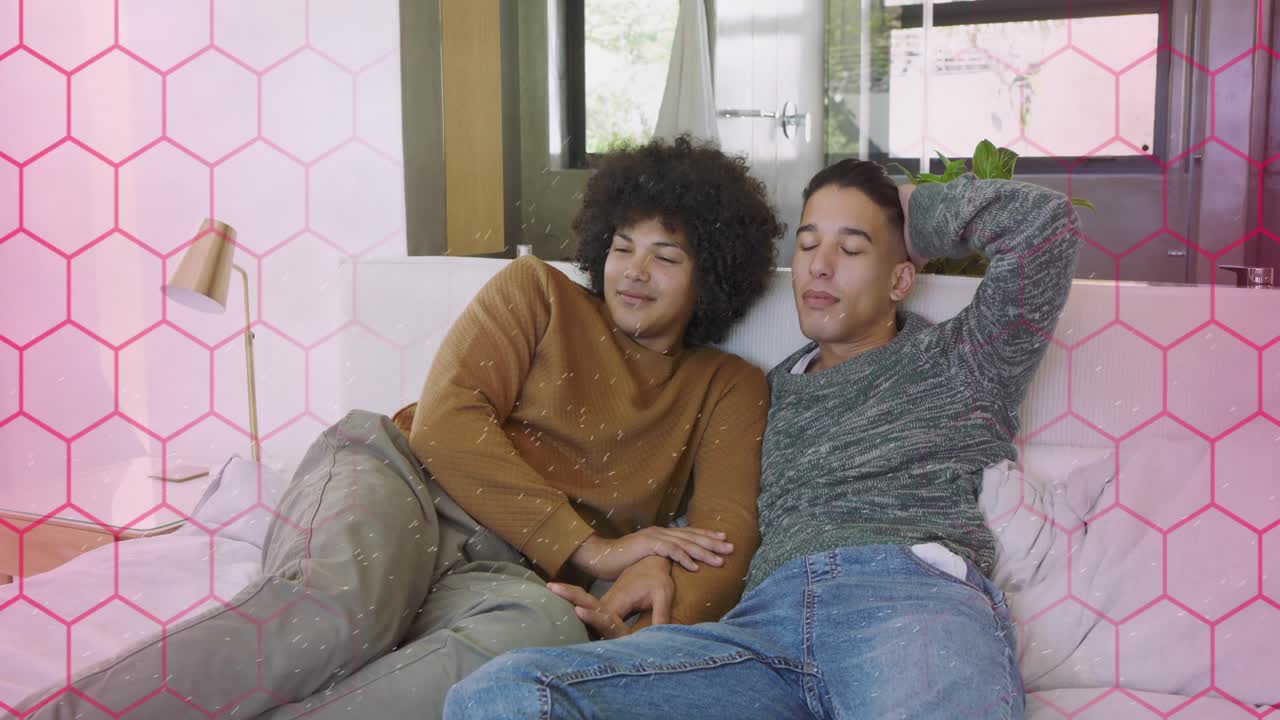 Curly man leaning into partner, seeking comfort for marketing on bed, pink hex framing left, flare