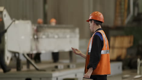 factory worker inspecting machinery