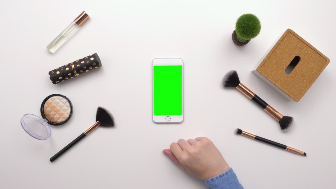 아름다움 제품에 의해 스마트폰을 사용하는 여성의 상단 뷰