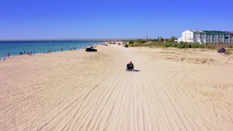 riding a four-wheeler down a beautiful tropical beach under the hot sun.