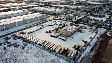 outdoor warehouses with trailers parked closely together in the middle of winter