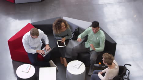 four students working in the foyer of a university, elevated view, shot on r3d