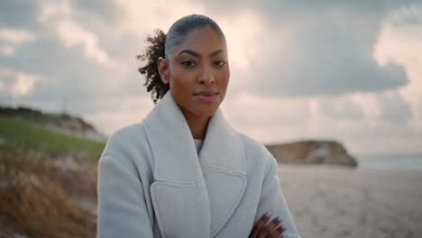 Portrait-cheerful-woman-resting-autumn-beach.-Happy-african-american-posing