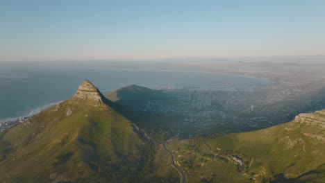 Panoramaaufnahmen-Aus-Der-Luft-Der-Metropole-Zwischen-Bergen-Und-Meeresbucht.-Sonne-Scheint-Auf-Der-Felsspitze-Des-Löwenkopfberges-über-Der-Stadt.-Kapstadt,-Süd-Afrika