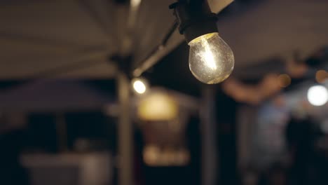 Shallow-Focus-Of-Transparent-Lamp,-Water-In-Bulb,-Christmas-Market