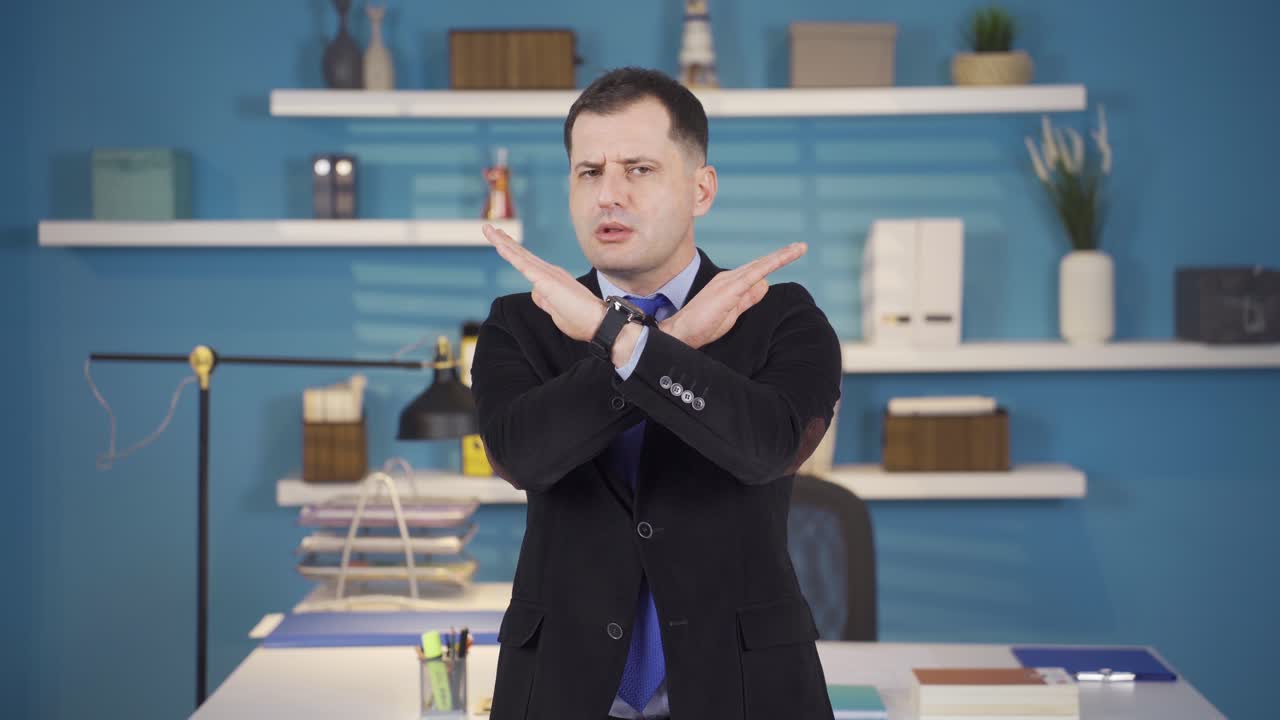 Businessman making 'NO' sign looking at camera.