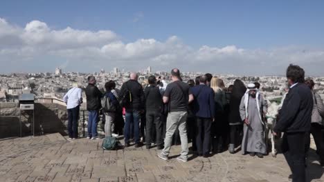 tourists enjoying the view of jerusalem from a historical vantage point.