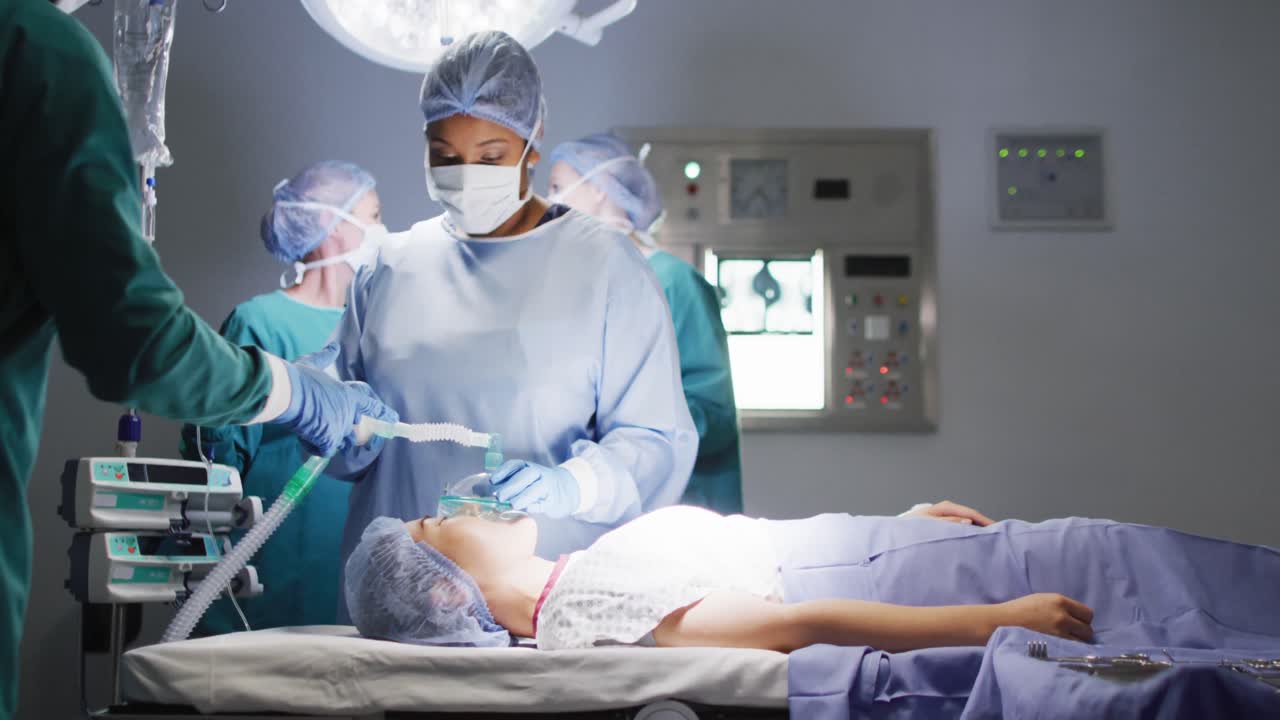 video de una asistente quirúrgica biracial dando gas a una paciente asiática en el quirófano