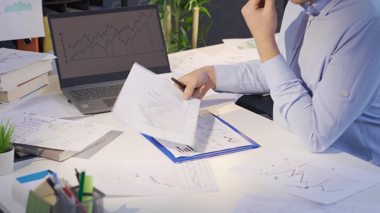 hombre comparando y analizando gráficos digitales y dibujados.