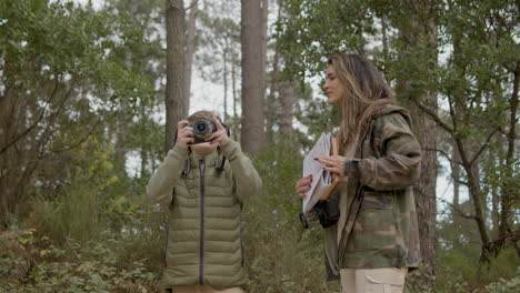 mujer caucásica y su hijo explorando la vida silvestre y la observación de aves en un parque natural el día de otoño