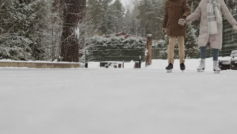 couple ice skating in winter park