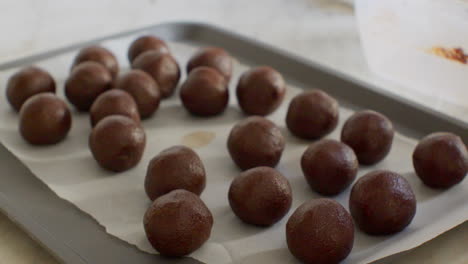 Push-in,-slide-shot-of-woman-preparing-and-giving-shape-to-homemade-chocolate-cake-pops