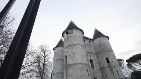 push past metal gated fenceline to reveal castle on cloudy overcast day, vernon france