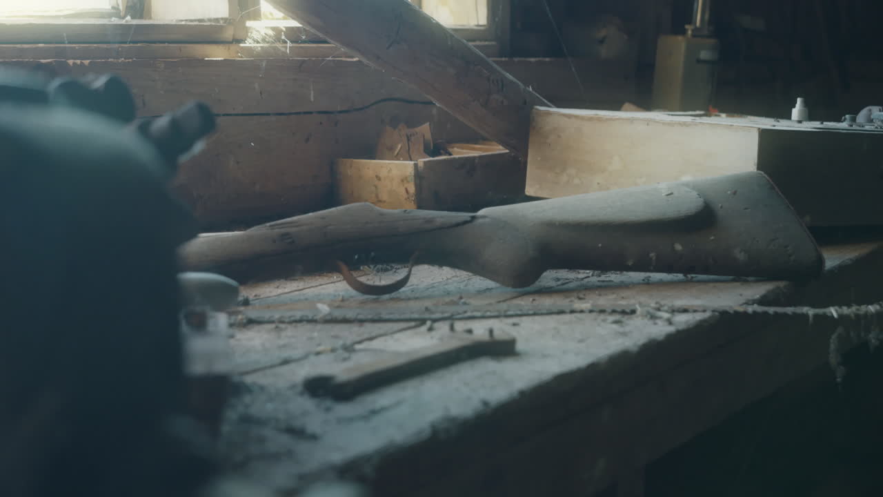 빈티지 사냥 소총은 창고의 오래된 먼지 작업 벤치에 놓여 있으며,  ⁇ 을 드러 ⁇ 니다.