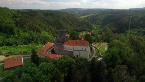 Luftdrohne-Umkreist-Die-Umgebung-Mit-Blick-Von-Oben-Auf-Das-Historische-Europäische-Schloss-Svojanov-In-Grünen-Bergen,-Tschechische-Republik