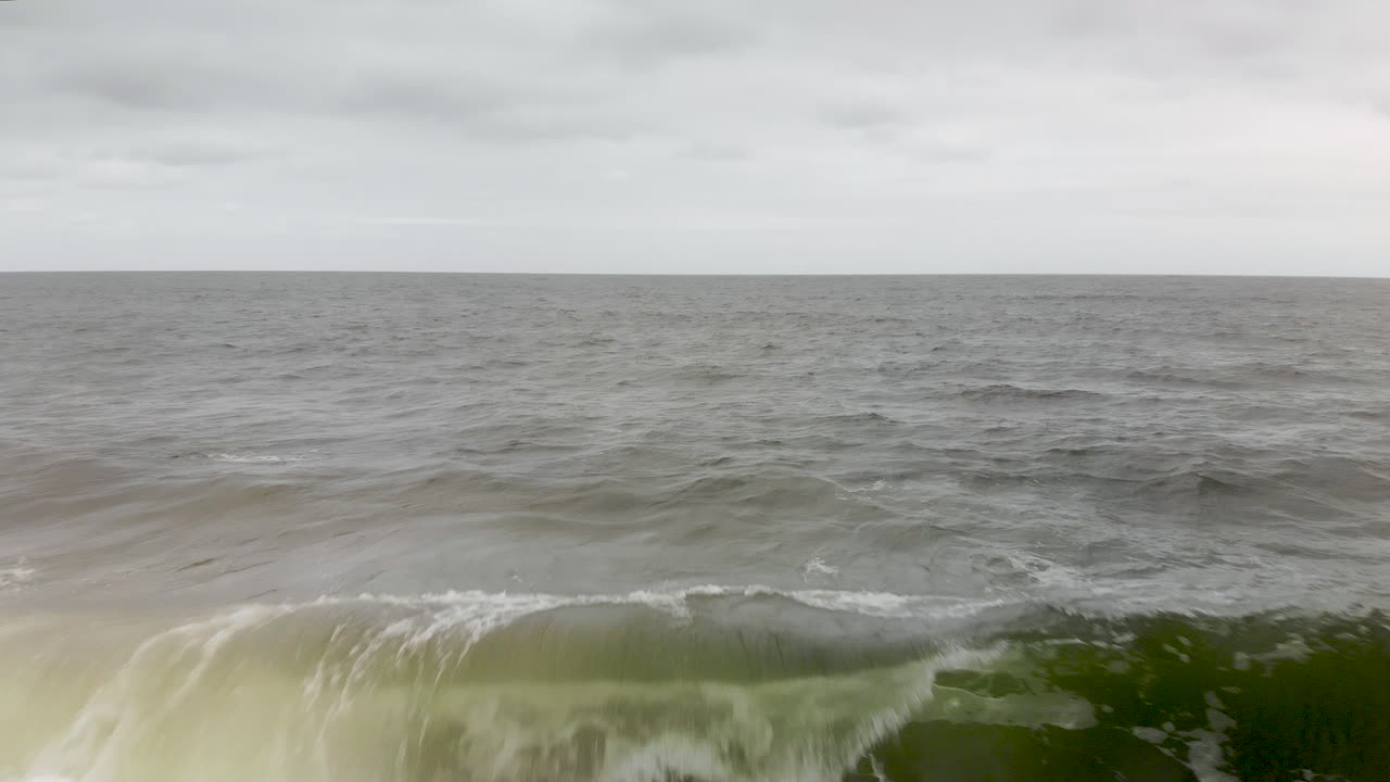 해안선에 충돌하는 파도 위의 공중 비행