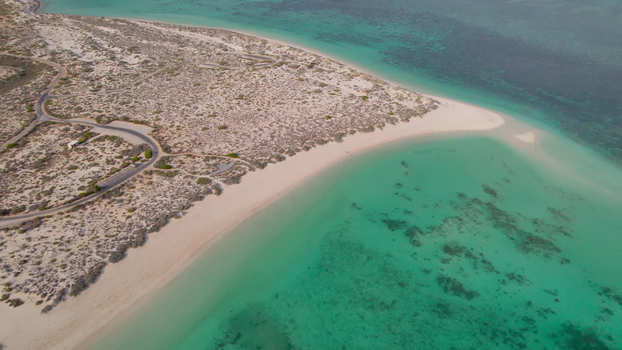 En drone flyver fremad over kystfarvandet ved Turquoise Bay, Ningaloo Reef og Cape Range National Park og fanger klare turkise lavvandede områder, hvidt sand, revteksturer og kystklipper ovenfra