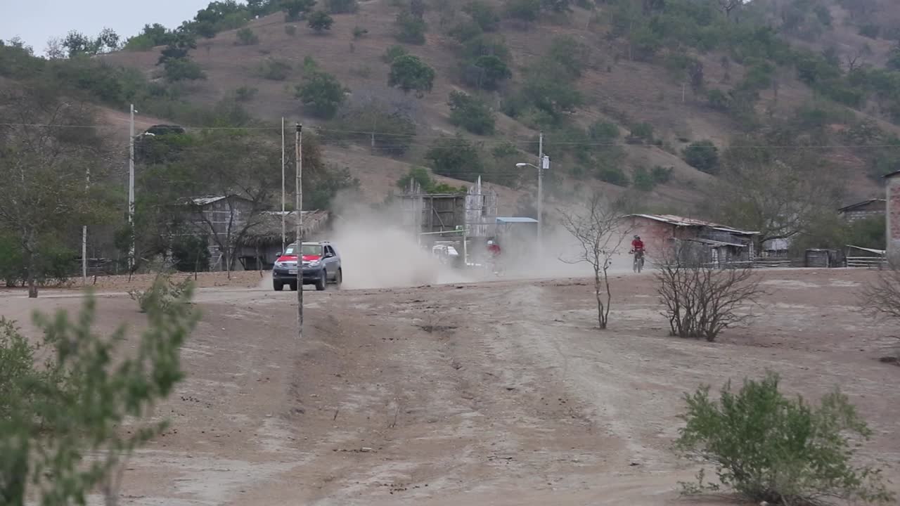 atletas de maratón en bicicleta por un camino de tierra con bicicleta de montaña montando detrás de una camioneta haciendo nubes de polvo selva desierto ecuador - 50 fps