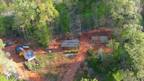 Vuelo-De-Drones-Sobre-Un-Pequeño-Lote-Fuera-De-La-Red-Con-Casa-Verde