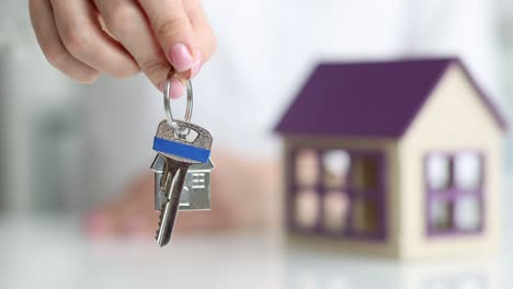 agent holds key to house in hand closeup