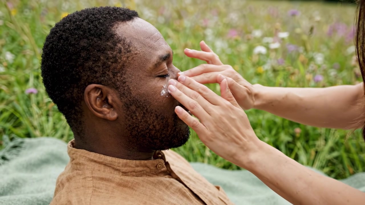 Relaxation and Self-Care: A Man Enjoying a Spa Treatment in Nature, Receiving Gentle Touches and Skin Care Amidst a Beautiful Floral Setting on a Sunny Day