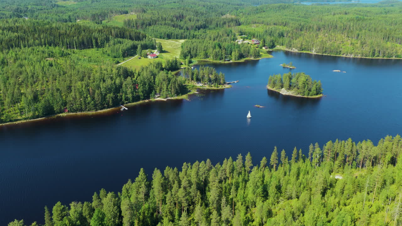 Panoramic drone shot circling a sailboat on lake Saimaa, summer day in Finland