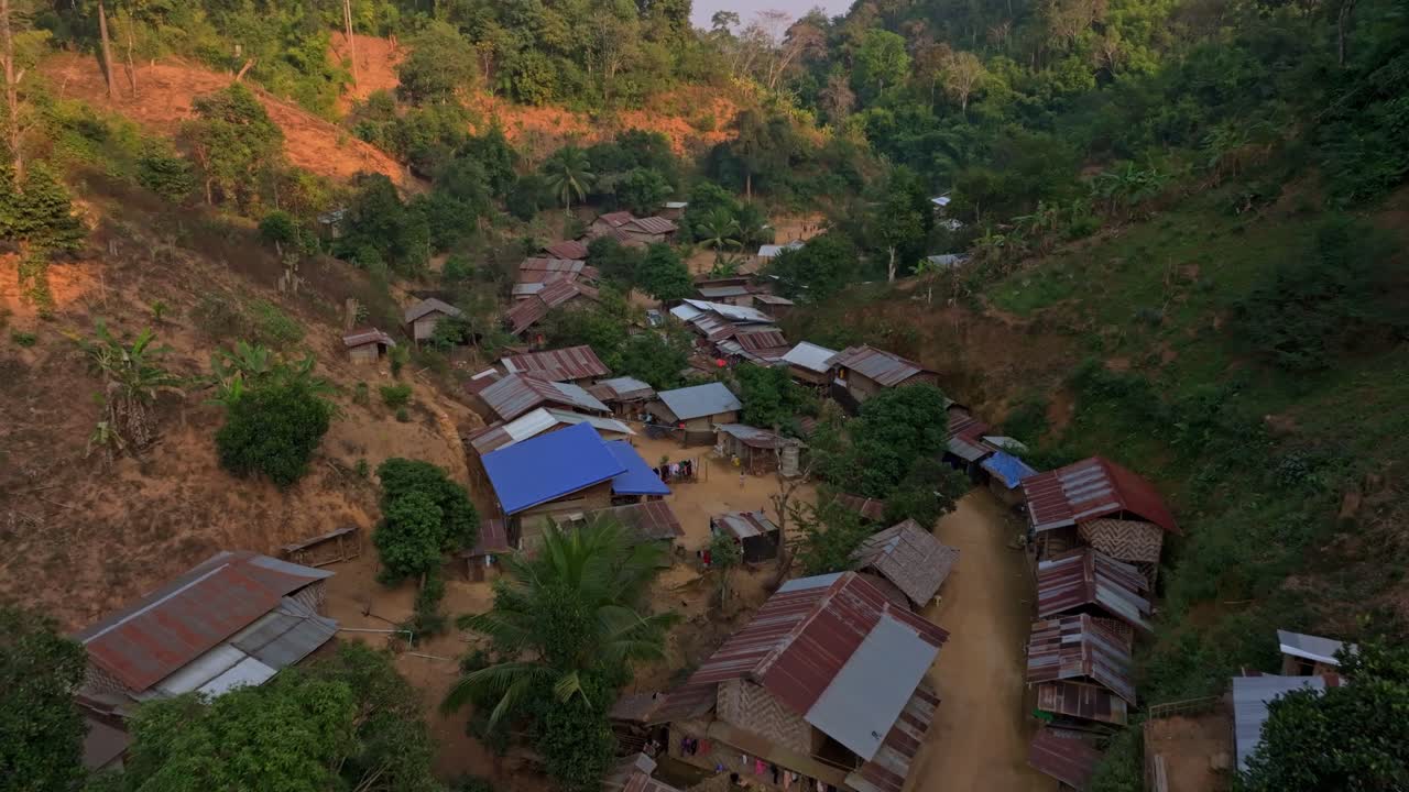 Skovkronen omkranser stille etniske landsbyhuse, Thailand.
