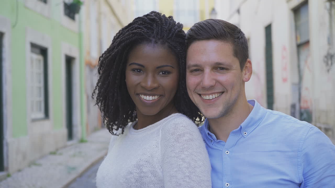 Happy multiracial couple looking at camera.