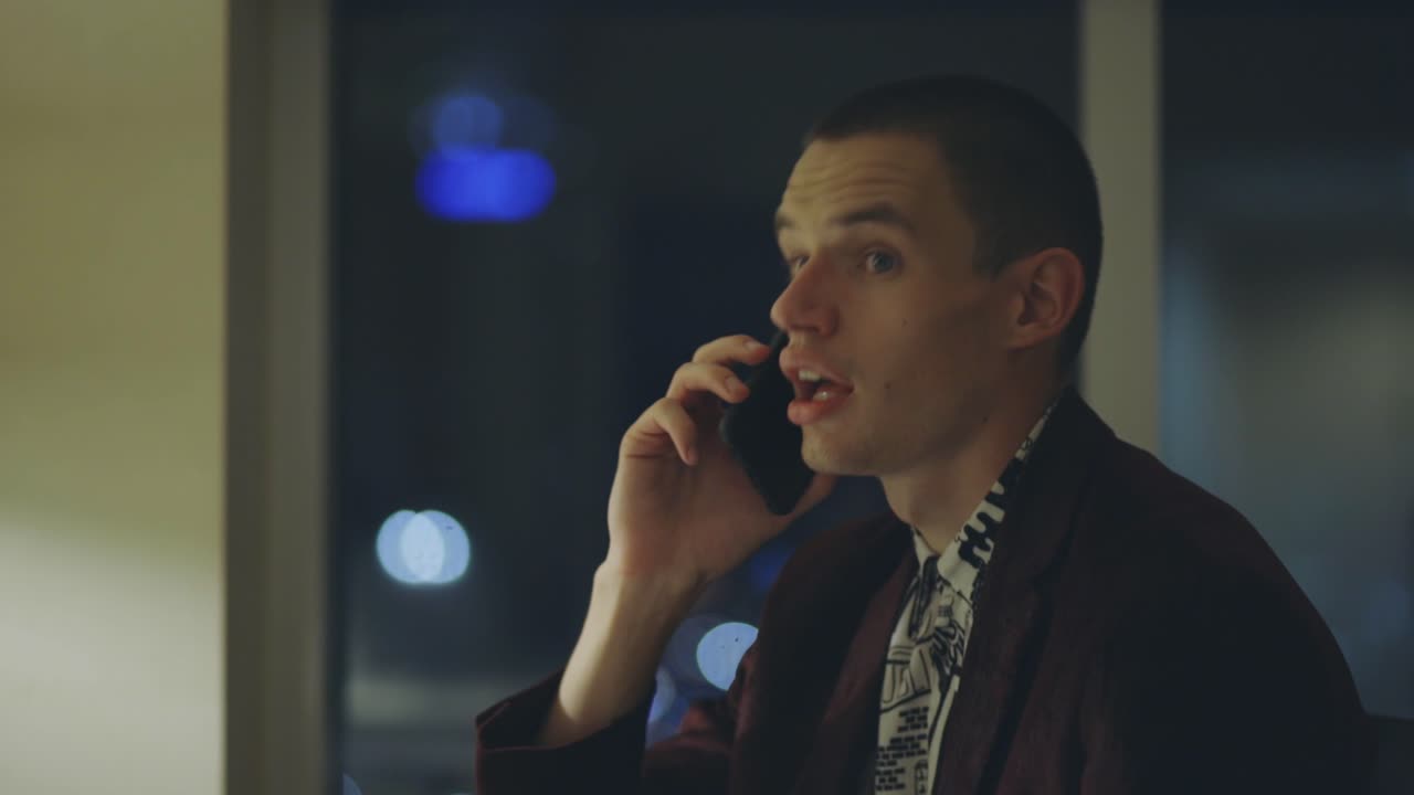 밤에 백인 남자가 전화를 걸고 스마트폰으로 누군가와 이야기를 나눈다 - 중간 가까이