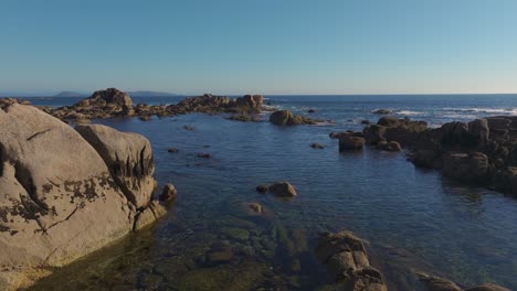boulders at the seacoast of con negro beach in san vicente do mar, o grove in galicia, pontevedra, spain. aerial drone shot