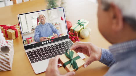 senior biracial man having christmas video call with senior biracial man