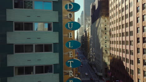 Horizontally-fly-along-decorated-brick-wall.-Sliding-reveal-of-busy-Lexington-avenue-lined-by-large-buildings.-Manhattan,-New-York-City,-USA