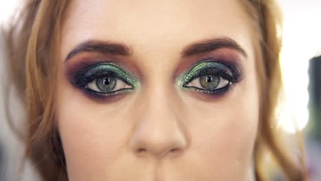 Fabulous-bright-haired-woman-with-beautiful-green-eyes-makeup-opens-her-eyes.-Front-view